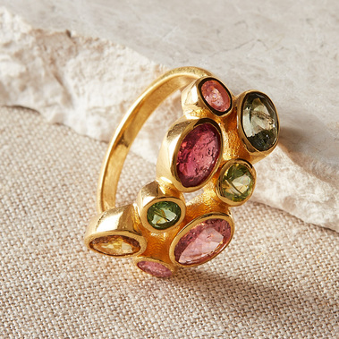 Multi coloured tourmaline gemstone ring on a natural coloured linen background