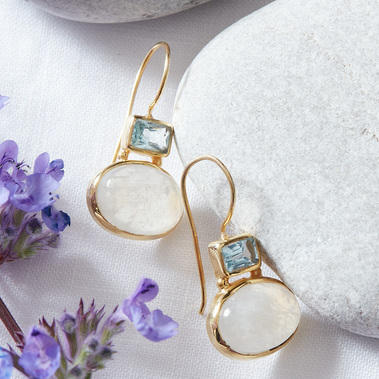 Lifestyle jewellery photography UK gold earrings styled with pebbles and flowers