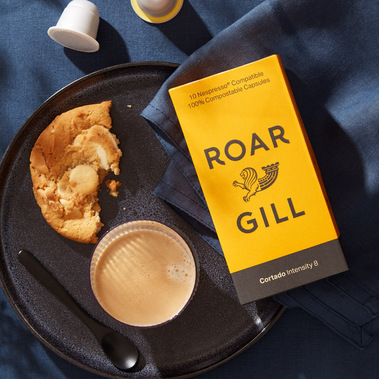 Coffee product photography.  Fresh black coffee with crema and a broken biscuit