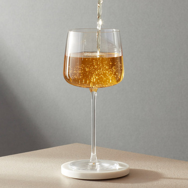 Premium cold brew tea being served in a glass, with daylight shadows on a grey background