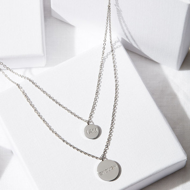 Jewellery photography, a silver necklace on a white geometeric background