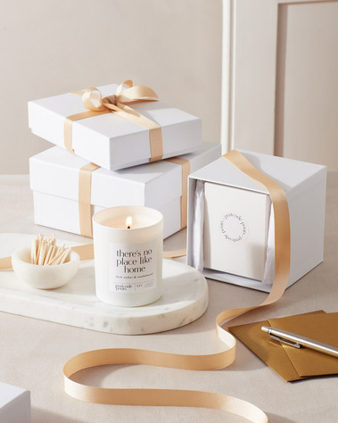 Candle product photography,  a candle with gift box, gold ribbon and matches