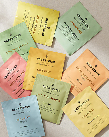 A selection of herbal teabags on a neutral background with daylight shadows