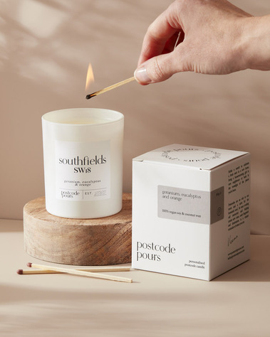 Lifestyle candle photography with a hand model on a neutral background