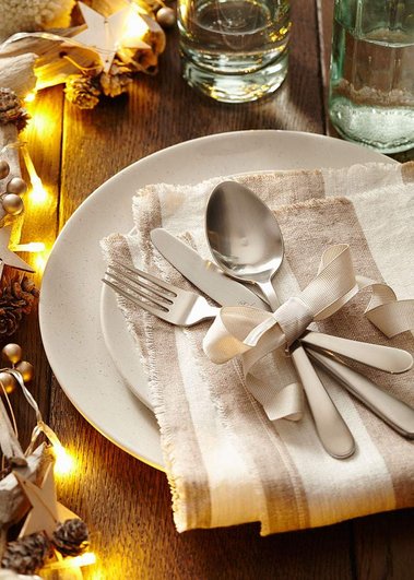 Christmas product photography of dinner plates, with a napkin and fairy lights.