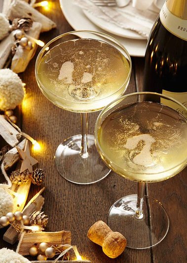 Christmas product photography of two coupe champagne glasses with fairy lights.