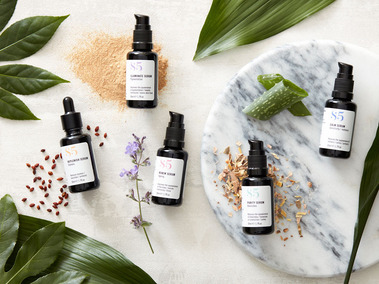 Lifestyle beauty product photography Skincare products with ingredients and fresh foliage