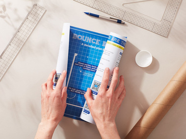 Stationary photography showing a blueprint being unrolled