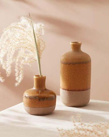 Homeware product photography of two brown ceramic vases with dried flowers.