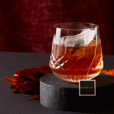 Chocolate chilli tea served in a crystal glass on a moody dark background