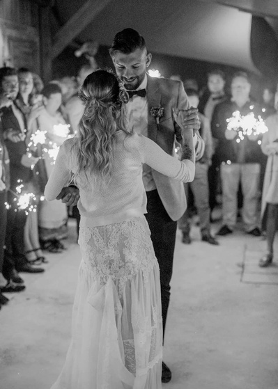 Hochzeitspaar tanzt umringt von Gäste  mit Wunderkerzen
