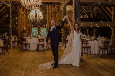 Brautpaar tanzt in der Party Scheune Location und an der Decke sind riesige Kronenleuchte