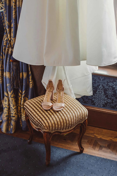  Hochzeitsschuhe als Detail im Vordergrund von Hochzeitskleid