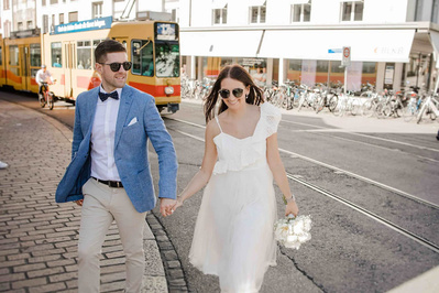 Das Brautpaar Hand in Hand auf dem weg zum Aper durch die Stadt Basel in Sonnenbrillen 