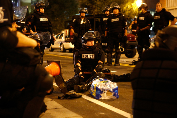 CHARLOTTE, NC - SEPTEMBER 21: Police officers take a moment to rest after a night of clashing with rioters protesting the death of Keith Scott September 21, 2016 in Charlotte, North Carolina. Keith was shot and killed by police officers at an apartment