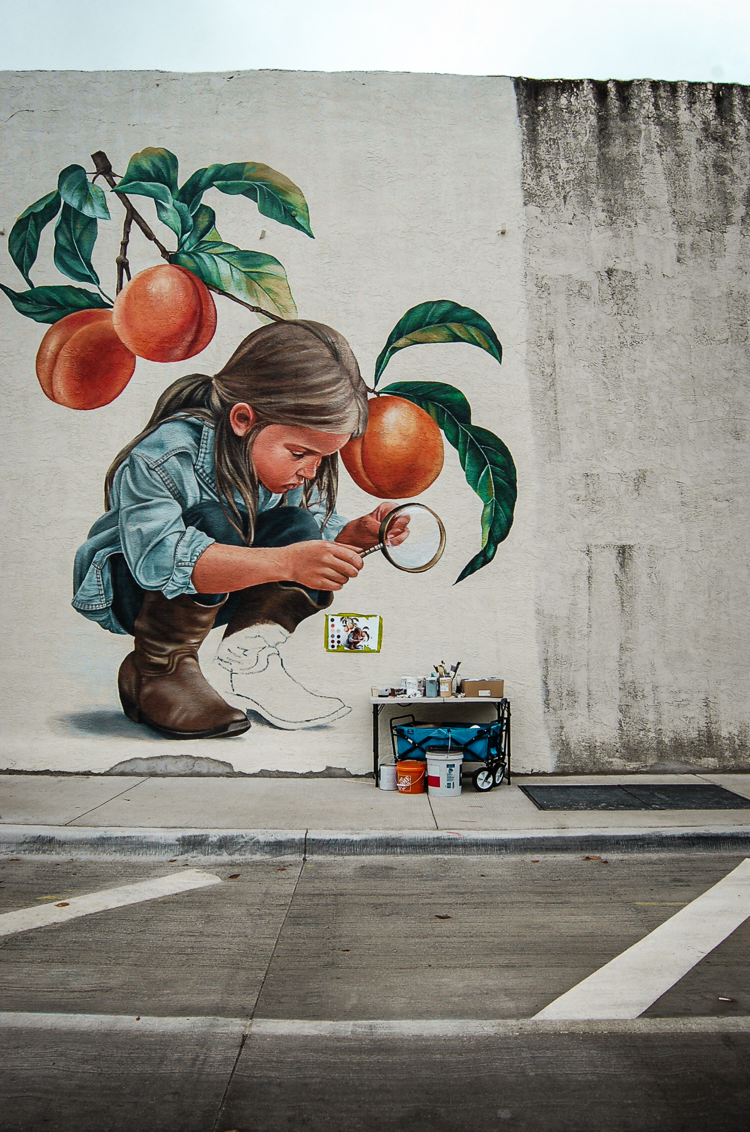 Curiosity, paused mid-thought. A half-finished boot, a fruit too ripe. Time is not stopped—it’s focused. And in that quiet concentration, we see a softer kind of strength.