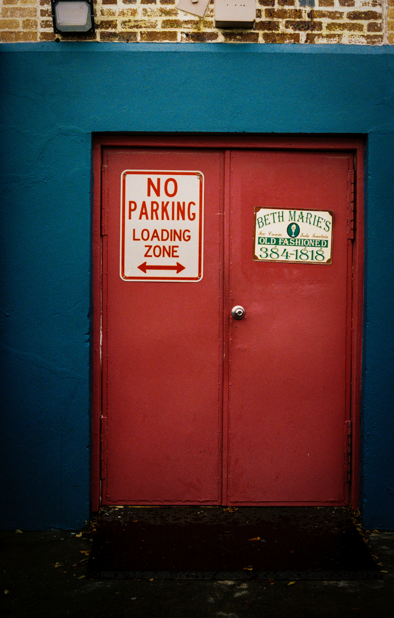 A quiet loading zone, flanked by bold reds and blues. This back entrance to Beth Marie’s speaks to the poetry of workday rituals, signage, and the unseen flow of a city behind the scenes.