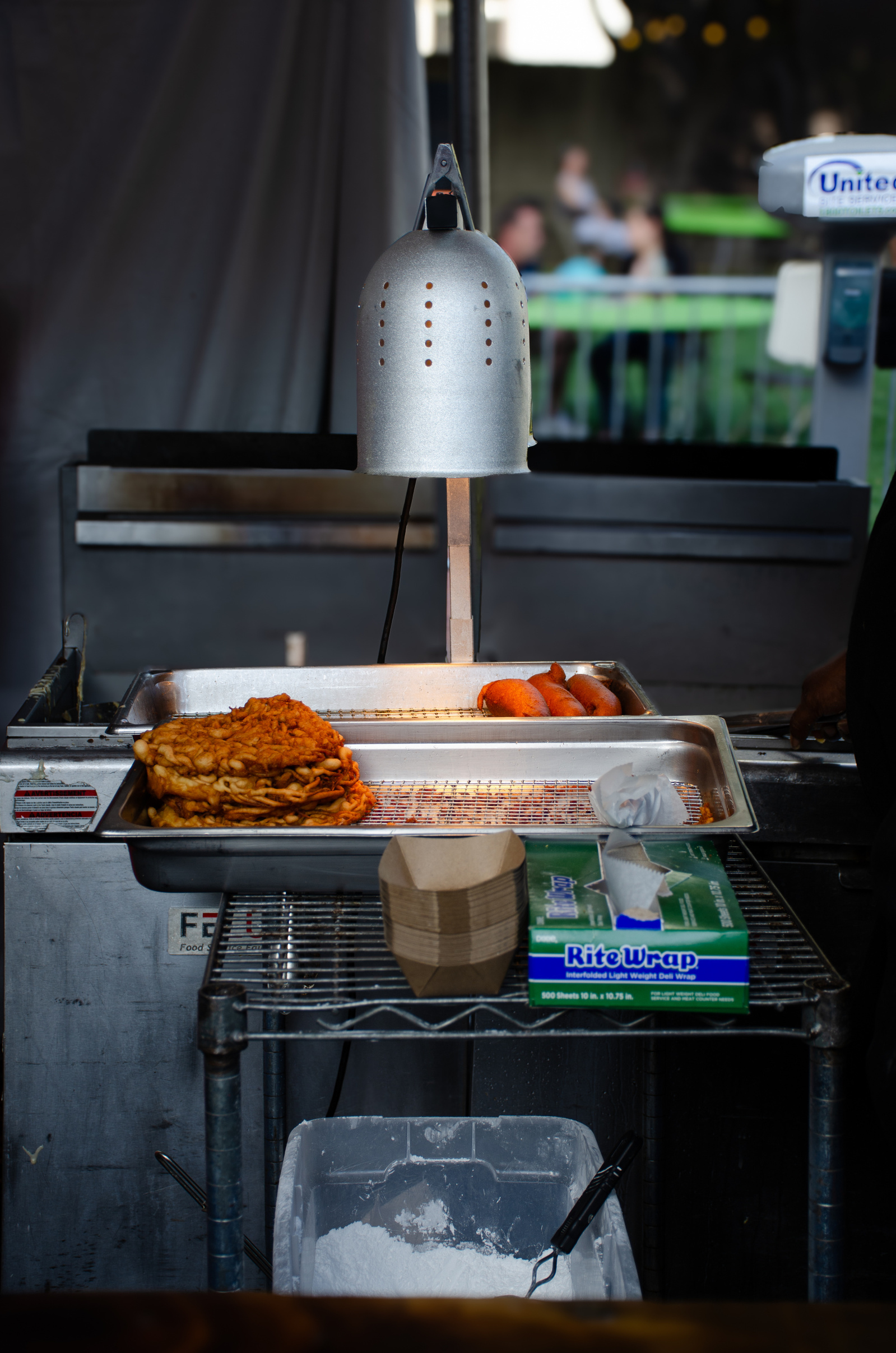 Art in the arrangement: fried edges, glowing heat lamp, and the quiet prep behind indulgence.