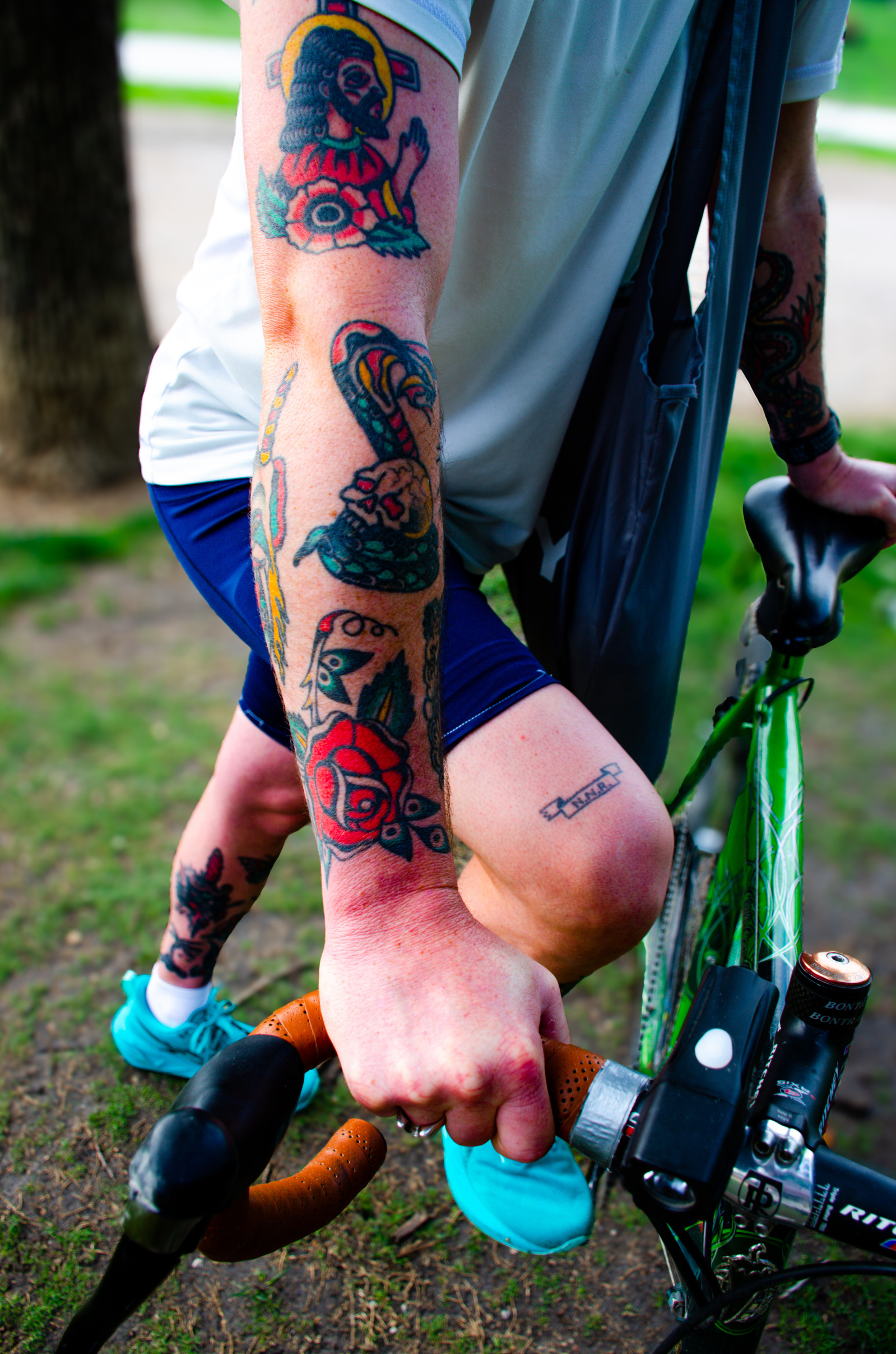 Gripped handlebars, exposed ink, a flash of muscle and sweat. Tattoos wrap around limbs like armor, each one a story powered by pedals and persistence.