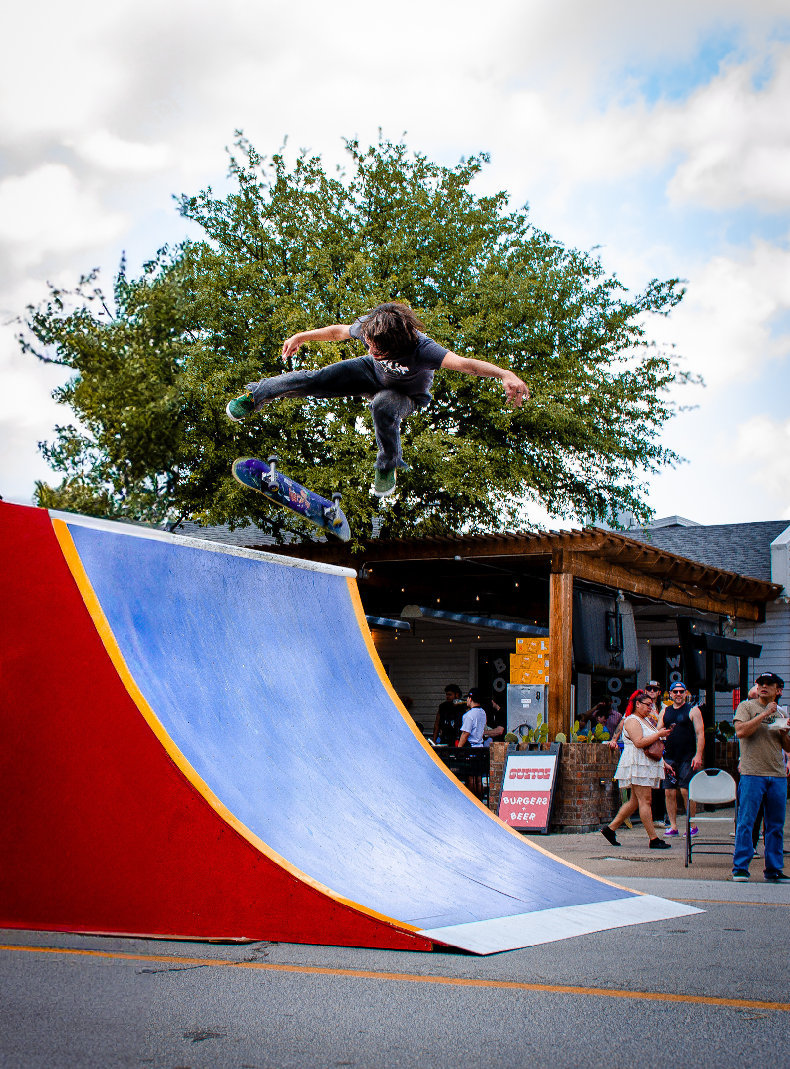 A skater levitates off the curve of the ramp in a full eruption of movement—board twisting, limbs extended. There’s no up or down here, only the blur between gravity and intention.