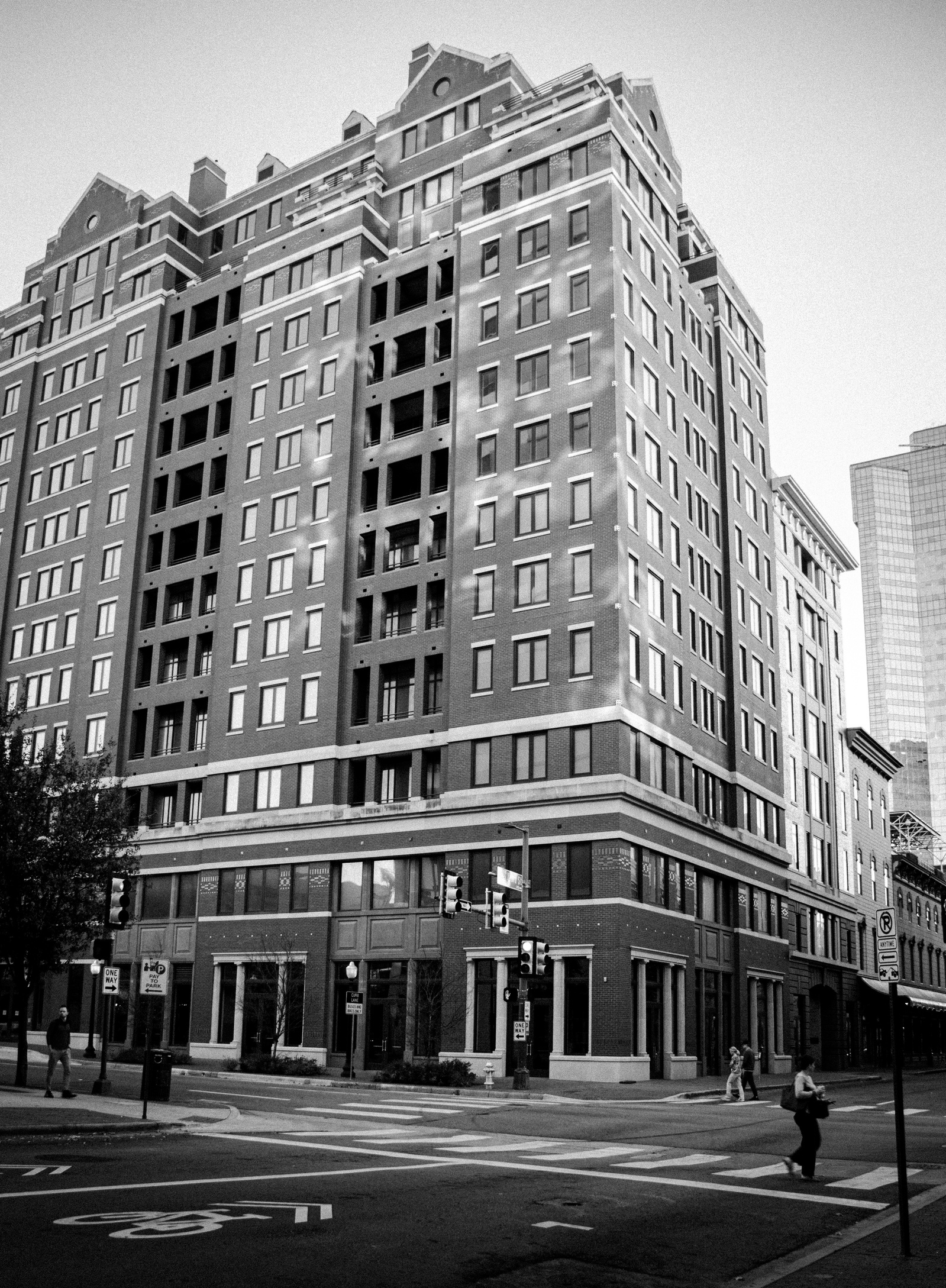 All those windows, none looking back. There’s a presence in absence—stories suspended behind glass. The building feels lived in but not seen, waiting without urgency.