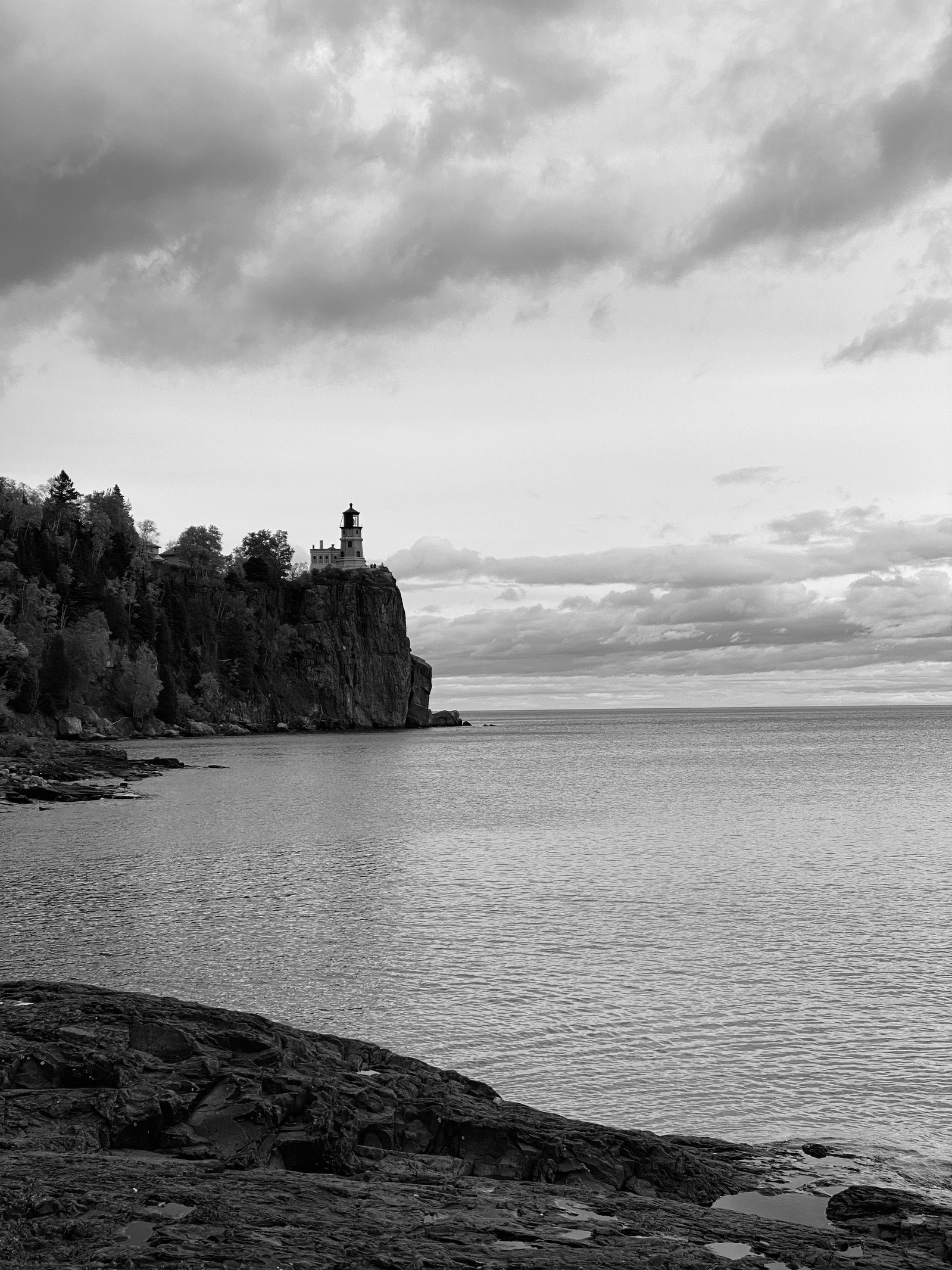 Perched at the edge of permanence, the lighthouse watches over a silence that no longer needs saving. Its light is out, but it still stands — not to guide, but to remember.