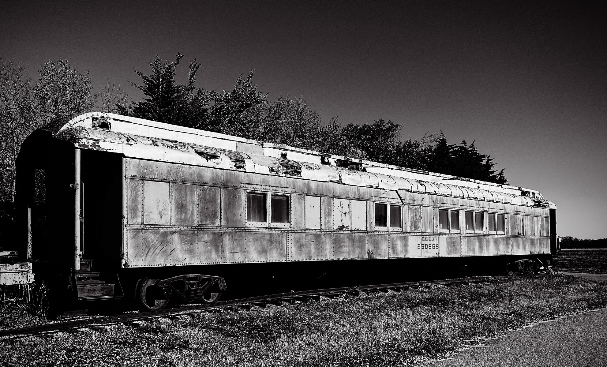 An abandoned passenger car, rust-creased and blistered under the trees. It’s haunting, still dignified, like a washed-up cruise liner of the rail era, left to remember for us.