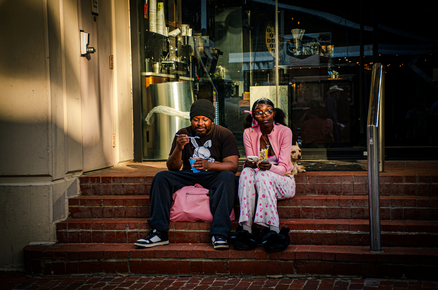 A quiet kind of intimacy—shared food, soft laughter, and a dog curled into the rhythm of the moment.