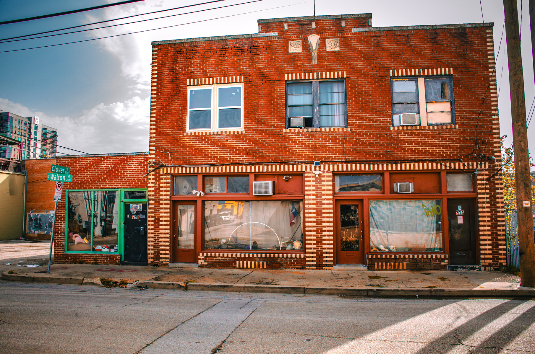 Old bricks and crooked blinds frame the block’s stubborn endurance. This building’s not waiting for your approval—it’s still here.
