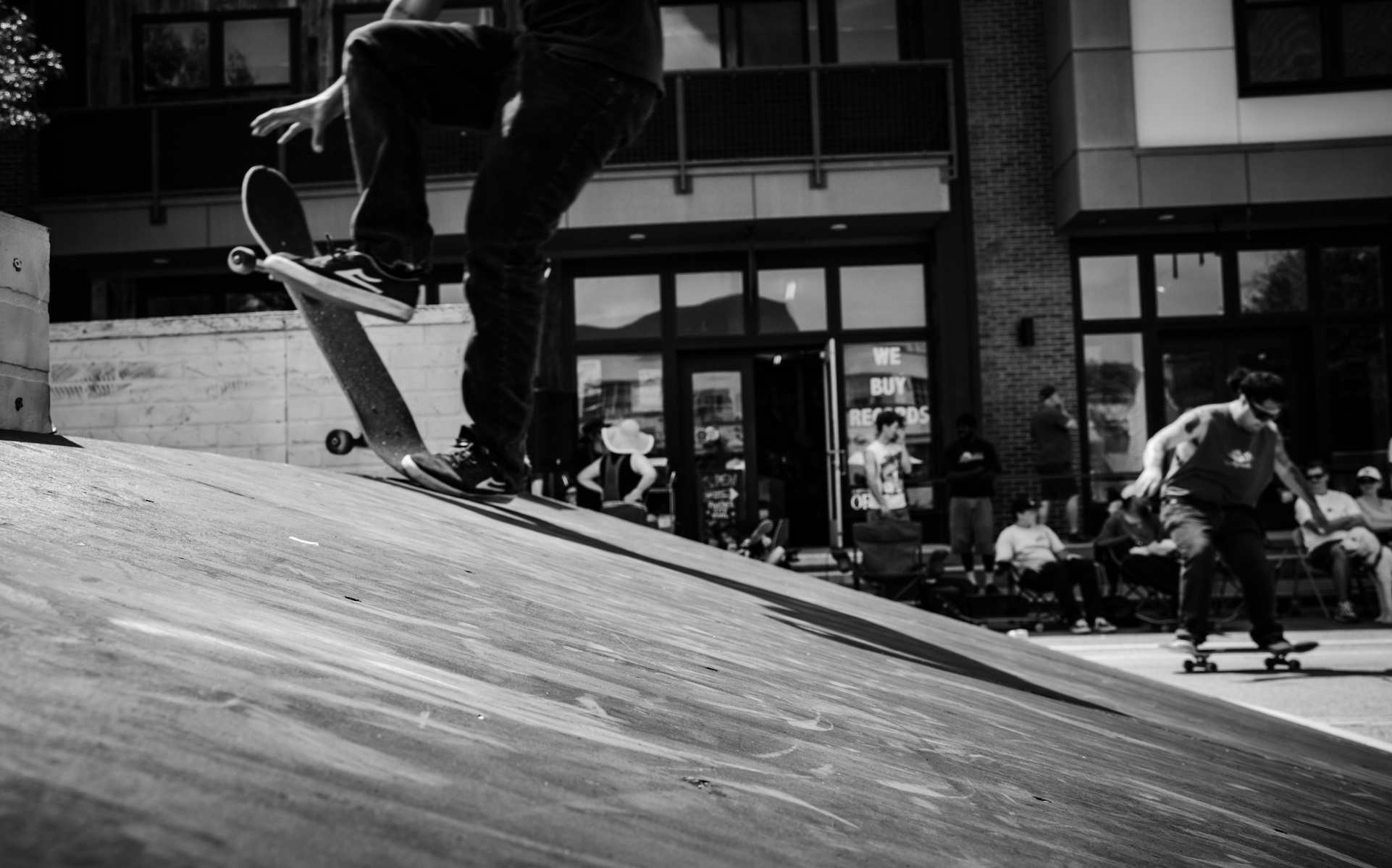 Energy surges from every corner of the frame—a blur in the background, a foot mid-flick, a crowd paused in their own rhythm. This black-and-white capture leans into the pulse of the scene, where each detail hums with motion and resistance.