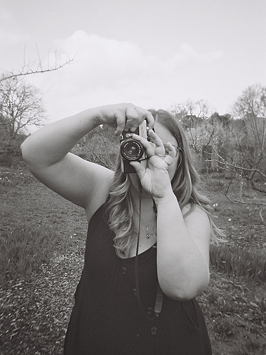 LGBTQIA + queer photographer holding 35mm film camera to capture your best moments